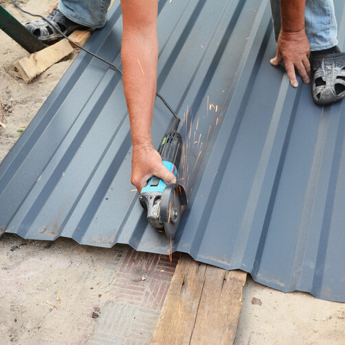 a worker installing metal roofing