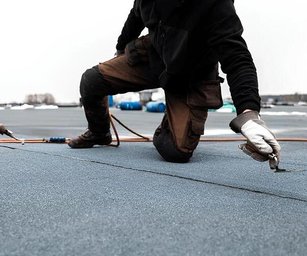 worker on a modfiied bitumen roof